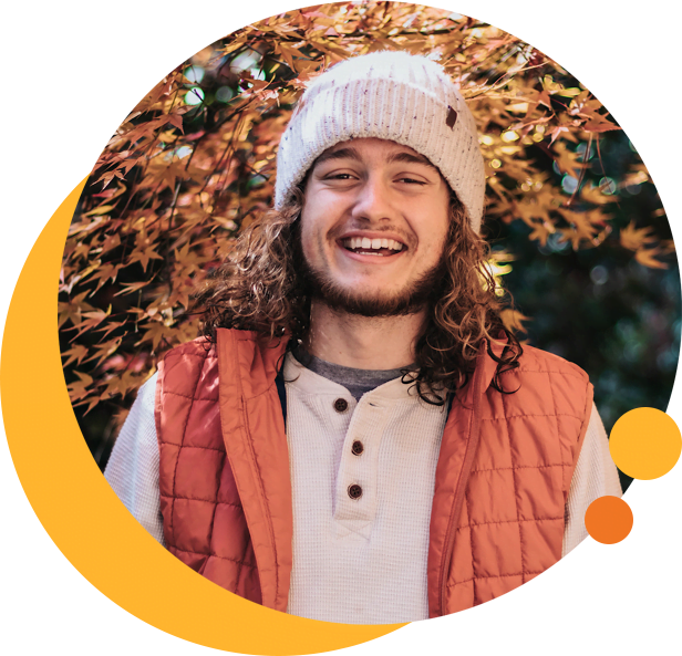 smiling young man in winter vest and beanie