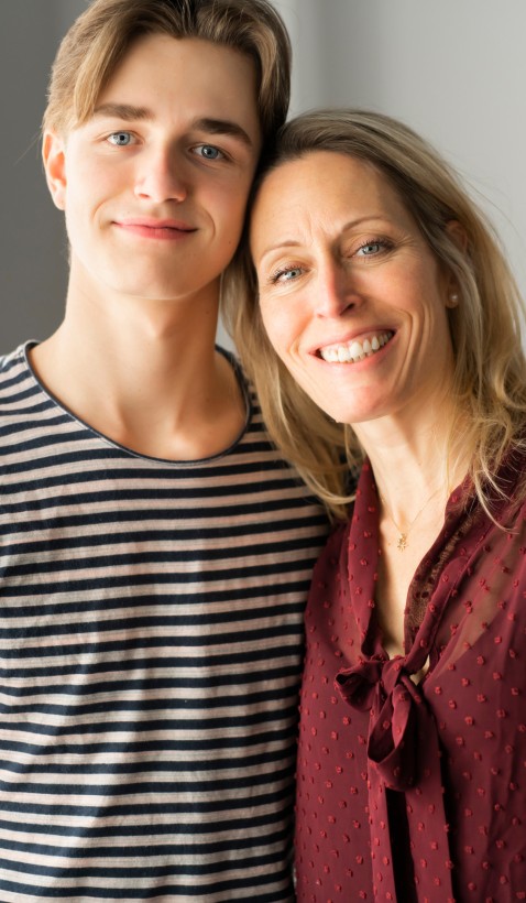 caucasian mother and son leaning together and smiling